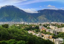 „Diejenigen, die noch an der Macht sind, stehlen uns die Hoffnung“ Das Bild zeigt die Haupstadt Venezuelas, Caracas. Sie ist umgeben von einem Gebirge.