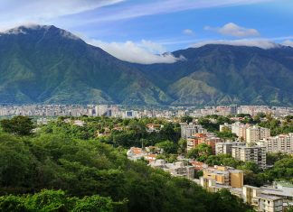 „Diejenigen, die noch an der Macht sind, stehlen uns die Hoffnung“ Das Bild zeigt die Haupstadt Venezuelas, Caracas. Sie ist umgeben von einem Gebirge.