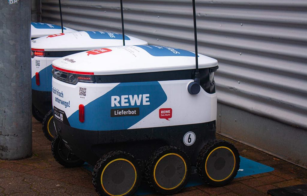 Einige Lieferbots stehen vor dem Supermarkt in Reihe und warten auf ihren Einsatz