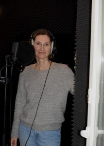 Margit Sander mit Kopfhörern auf lächelt in die Kamera