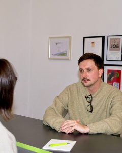 Alexander Streif sitzt in seiner Agentur, New Communication, am Schreibtisch. Foto: Fotograph Arne Ketelsen, New Communication