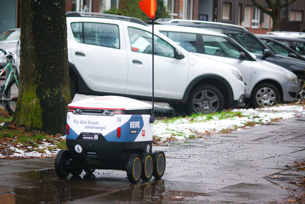 Der Lieferbot fährt auf dem Gehweg. Bei Hinternissen hält er an und sucht sich eine Lösung