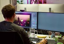 Freund oder Jobkiller? KI in der Werbebranche Ein Mann sitzt vor zwei Bildschirmen am Schreibtisch. Das Bild zeigt ihn von hinten. Foto: Lara Zschorsch