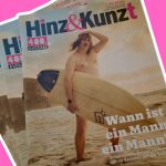 400 Mal “Hinz und Kunzt” – die Stimme der Obdachlosen Eine Abbildung von der 400. Ausgabe von Hinz & Kunzt. Auf dem Cover ist Schauspieler Robert Lindemann zu sehen wie er an einem Strand ein Surfbrett trägt.