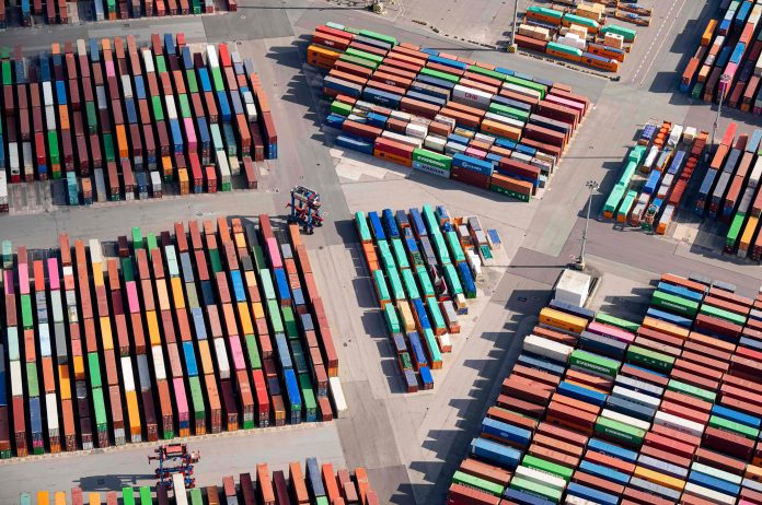 Mehrere Container in unterschiedlichen Farben liegen angeordnet in Gruppen auf dem Boden.