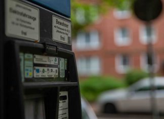 Parken in Hamburg wird deutlich teurer Nahaufnahme eines Parkautomaten bei Tag. Im Hintergrund verschwommen: ein Straßenschild und graue Autos.