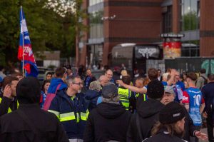 Demonstrierende und eine pöbelnde Gruppe werden von Polizei und Sicherheitskräften getrennt.