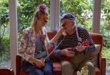 Ein Clown im Pflegeheim: „Mögt ihr Plattdeutsch?“ „Jaaaaa!“ Martin Schneider-Schall und Franziska Heuschkel sind Clowns im Pflegeheim. Sie tragen bunte Klamotten sowie eine rote Plastiknasen und sitzen auf einem Sofa zusammen.