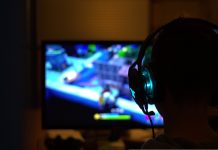 Jetzt wird entwickelt, getestet und gezockt Vor einem bunten Bildschirm sitzt eine Perosn mit Kompfhörern. Beim Game-Jam wird entwickelt und gespielt.