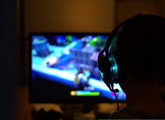 Jetzt wird entwickelt, getestet und gezockt Vor einem bunten Bildschirm sitzt eine Perosn mit Kompfhörern. Beim Game-Jam wird entwickelt und gespielt.