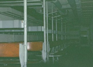 Wo finden wir Schutz im Ernstfall? Reihen von Sitzbänken in einem dunklen Luftschutzraum.