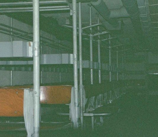 Wo finden wir Schutz im Ernstfall? Reihen von Sitzbänken in einem dunklen Luftschutzraum.