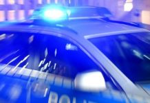 Drogenschmuggel: Polizei ermittelt gegen Drogennetzwerk Ein Streifenwagen der Polizei steht mit eingeschaltetem Blaulicht auf der Straße. Text über Drogenschmuggel.