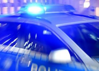 Drogenschmuggel: Polizei ermittelt gegen Drogennetzwerk Ein Streifenwagen der Polizei steht mit eingeschaltetem Blaulicht auf der Straße. Text über Drogenschmuggel.