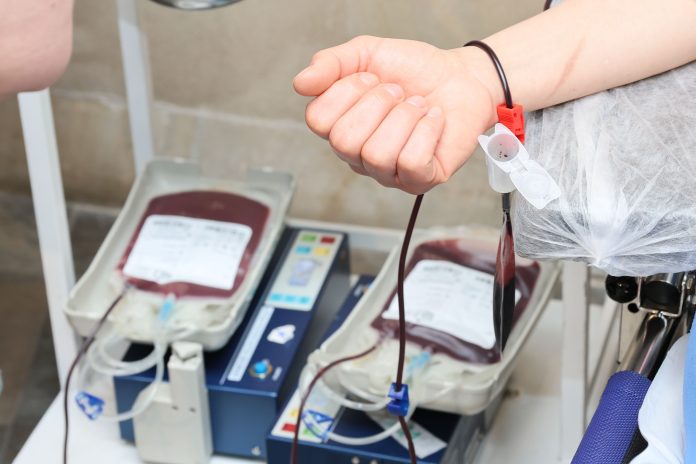 Eine Hand ist geballt über Blutbeutel.