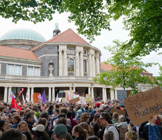 7000 gegen den Sparkurs: Studierende protestieren gegen Kürzungen Im Hintergrund ist das Hauptgebäude der Universität Hamburg, im Vordergrund viele Studierende mit Plakaten.