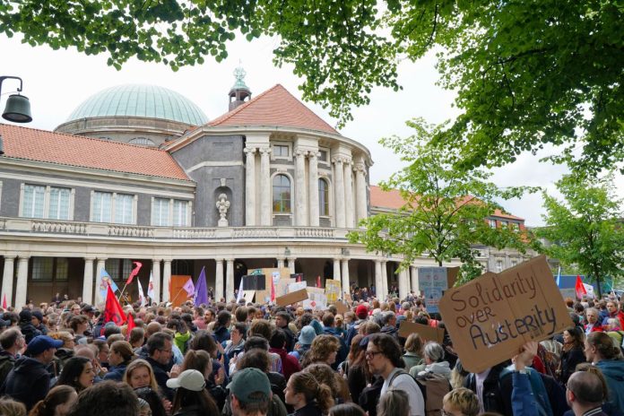 DSC00037br Im Hintergrund ist das Hauptgebäude der Universität Hamburg, im Vordergrund viele Studierende mit Plakaten.