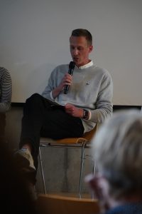 Historiker Lennart Onken bei einer Diskussion der Omas gegen rechts. Er trägt ein Mikro in der Hand.