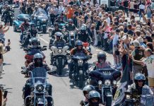 Harley Days in Hamburg: Sperren wegen Motorradparade erwartet Viele Motorradfahrer*innen fahren in Reihen über eine Straße in der Sonne.