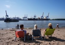 Hamburg, der Sommer ist da! Personen sitzen auf Liegestühlen am Elbstrand.