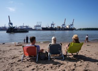 Hamburg, der Sommer ist da! Personen sitzen auf Liegestühlen am Elbstrand.