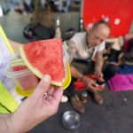 Hitzeschutz für Obdachlose: Diakonie Hamburg fordert mehr Maßnahmen Obdachlose Menschen in Hamburg werden bei Hitze unterstützt. Helfer hält Wassermelone in der Hand.