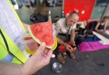 Hitzeschutz für Obdachlose: Diakonie Hamburg fordert mehr Maßnahmen Obdachlose Menschen in Hamburg werden bei Hitze unterstützt. Helfer hält Wassermelone in der Hand.
