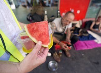 Hitzeschutz für Obdachlose: Diakonie Hamburg fordert mehr Maßnahmen Obdachlose Menschen in Hamburg werden bei Hitze unterstützt. Helfer hält Wassermelone in der Hand.