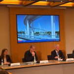 So soll die neue Köhlbrandbrücke aussehen 4 Personen sitzen in einer Pressekonferenz. auf einem Bildschirm hinter ihnen ist eine Visualisierung des Entwurfs der neuen Köhlbrandbrücke zu sehen.