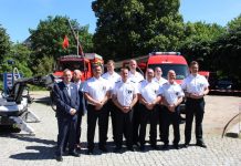 Bombenentschärfer Das fast vollständige Team des Kampfmittelräumdienst steht vor zwei roten Autos.