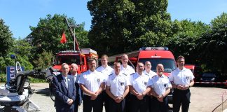 Bombenentschärfer Das fast vollständige Team des Kampfmittelräumdienst steht vor zwei roten Autos.