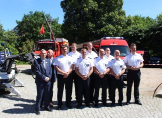 Bombenentschärfer Das fast vollständige Team des Kampfmittelräumdienst steht vor zwei roten Autos.