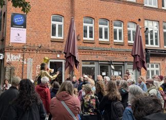 „Altona macht auf“: Tanz auf dem Balkon Eine Menschentraube steht im Hof der Zeisehallen und schaut zu einer Frau, die durch ein Megafon spricht.