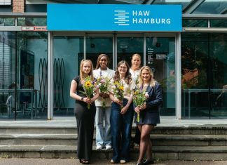 Preisverleihung beim Forschungstag der HAW 5 Frauen mit einem Blumenstrauß stehen vor dem Eingang eines HAW-Gebäudes.