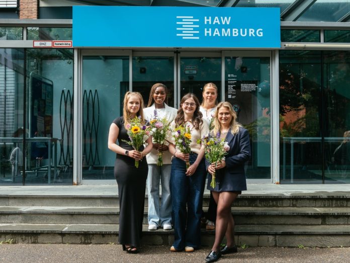 5 Frauen mit einem Blumenstrauß stehen vor dem Eingang eines HAW-Gebäudes.