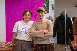 Marek Blanke und Joshua Memmer stehen vor einem Tisch mit Kleidung.