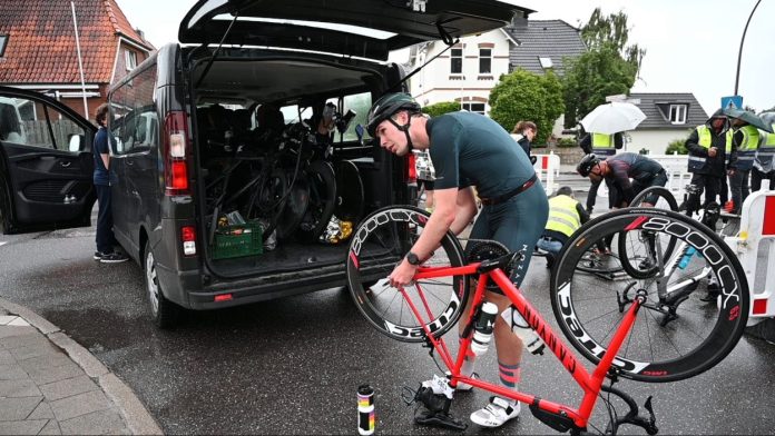 Triathlon_Europameis_89878918-2-2-3 Ein Triathlet repariert sein Rennrad am Rande des Rennens Ironman Hamburg.