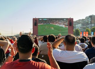 Hochbahn gönnt WM-Fans 20 Minuten Nachspielzeit Eine Menge an Menschen steht vor einem großen Bildschirm, auf dem ein Fußball-Spiel gezeigt wird.