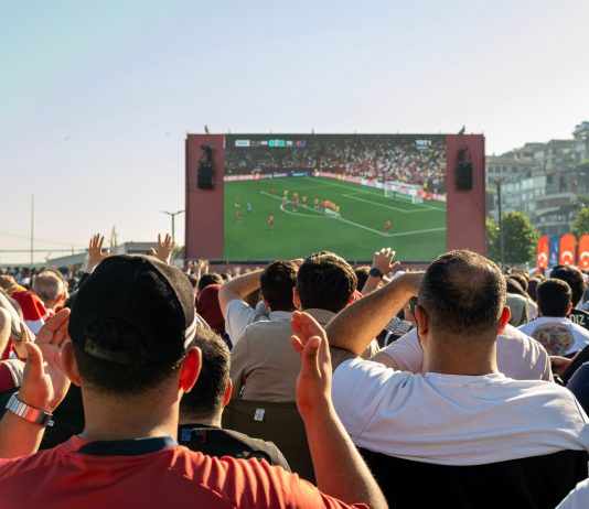Hochbahn gönnt WM-Fans 20 Minuten Nachspielzeit Eine Menge an Menschen steht vor einem großen Bildschirm, auf dem ein Fußball-Spiel gezeigt wird.
