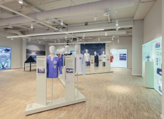 „Warum ist sie nicht gegangen?“ Sport im Nationalsozialismus Der Ausstellungsraum mit Informationstafeln an den Wänden und Figuren mit Trikots in der Mitte des Raumes.