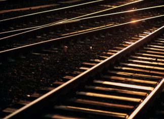 Nach mutmaßlichem Brandanschlag: Zugverkehr läuft wieder Gleise im Gegenlicht. Schotteroberbau mit Holzschwellen.