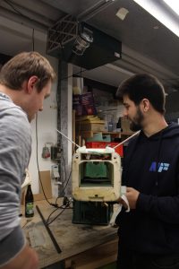 Chris Lucas Siewert und Fabian Kühn stehen vor dem Rumpf eines Modellflugzeugs.