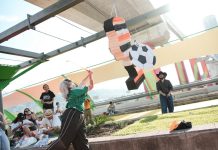 WM in Mexiko: Schießt das Land seine Notstände ins Rampenlicht? Eine Frau schlägt mit einem Stock auf eine Pinata, die aus einem Papp-Fußballspieler besteht, ein.