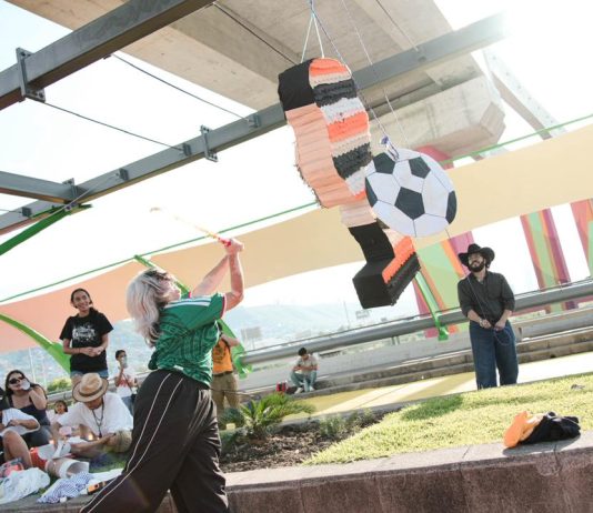 WM in Mexiko: Schießt das Land seine Notstände ins Rampenlicht? Eine Frau schlägt mit einem Stock auf eine Pinata, die aus einem Papp-Fußballspieler besteht, ein.