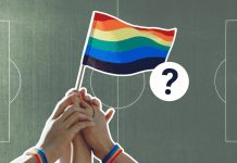 Fußball verbindet? So queerfreundlich ist die Männer-WM Im Vordergund ist eine Regenbogen-Flagge zu sehen. Im Hintergrund ist ein Fußball-Stadion.