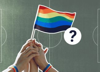 Fußball verbindet? So queerfreundlich ist die Männer-WM Im Vordergund ist eine Regenbogen-Flagge zu sehen. Im Hintergrund ist ein Fußball-Stadion.
