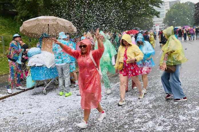 Schlagermove_Umzug_2_90103138-2 Menschen in bunten Kostümen feiern im Regen während des Schlagermove 2026.