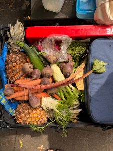 Auf dem Bild sieht man einen vollgefüllten Bollerwagen. Gefüllt ist er mit Obst und Gemüse.
