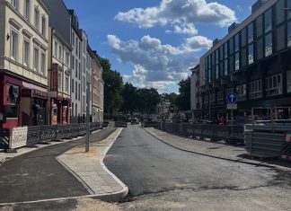 Erneut Verkehrseinschränkungen am Eppendorfer Marktplatz Das Bild zeigt eine Straße am Eppendorfer Marktplatz. Sie ist verschmutzt von Bauarbeiten. Links und rechts der Straße sind Wohnhäuser und Geschäfte zu sehen. Der Himmel ist blau. Die Sonne scheint.